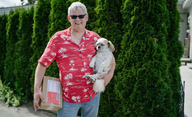 Terje med pakke og en hund i armene. 