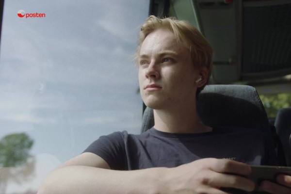 Ung student sitter på bussen og ser ut av vindu