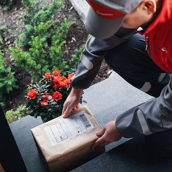 Postbud leverer pakke utenfor døren