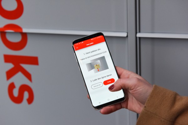 Posten-appen på mobil foran en Pakkeboks