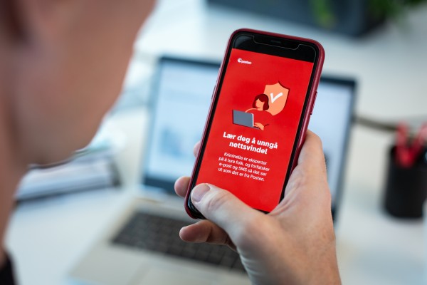 Mobiltelefon i en hånd viser tips om nettsvindel.