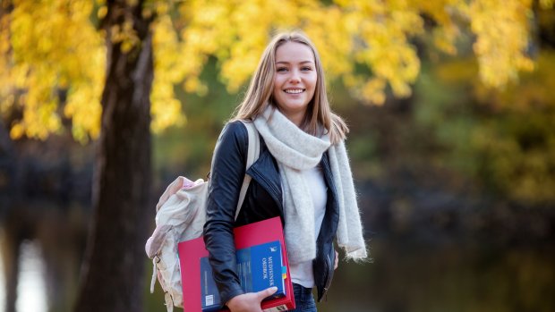Student med perm og bok under armen