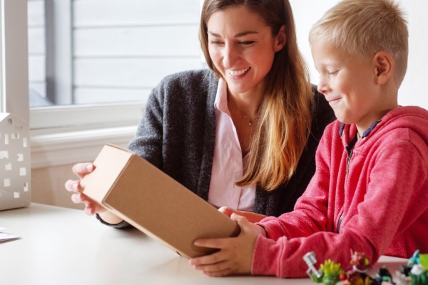 Mother and son opening a parcel by the table