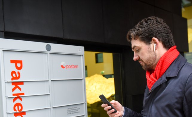 Parcel box and a man using his smartphone