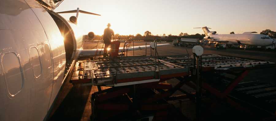 Airplane loading parcel in the sunset