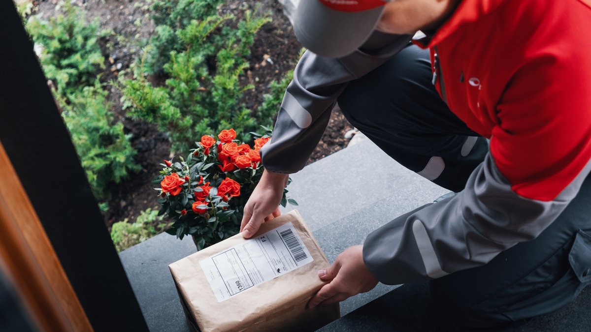 Postbud legger pakke utenfor dør