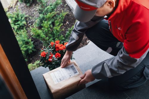 Postbud legger pakke utenfor dør