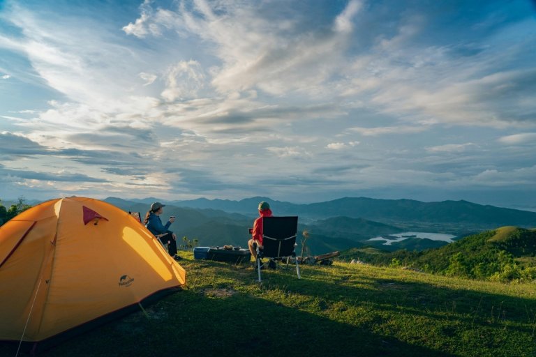 To personer foran et telt med flott utsikt og norsk natur