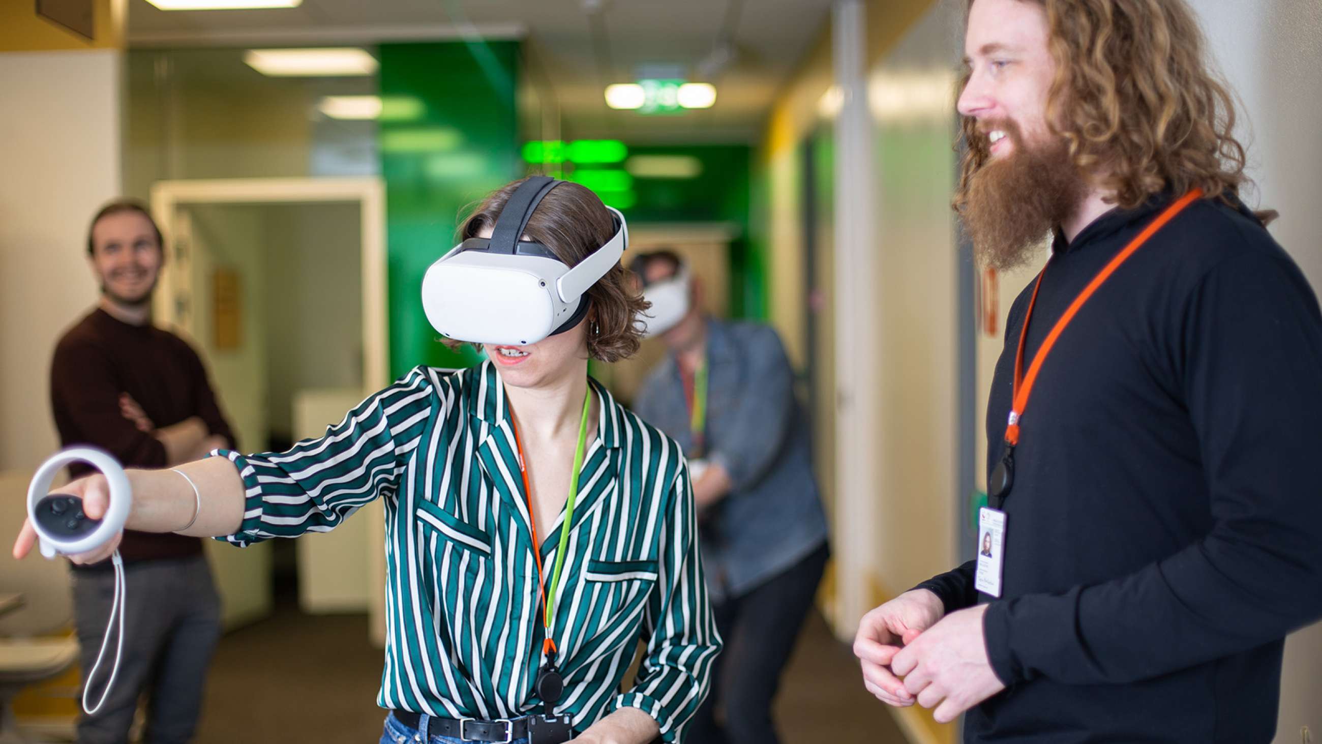 Arbeidsmiljø. En kvinne har på seg VR-briller og beveger hendene med fjernkontroller.