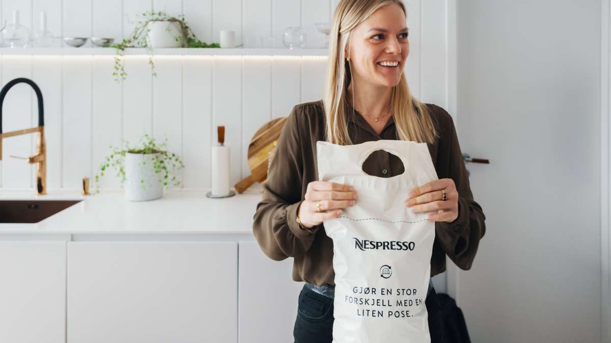 Kvinne med Nespresso-pose til gjenvinning