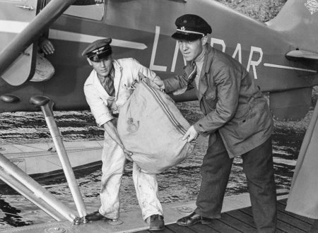 Postfrakt med sjøfly i 1936. To menn lemper tung postsekk ombord.