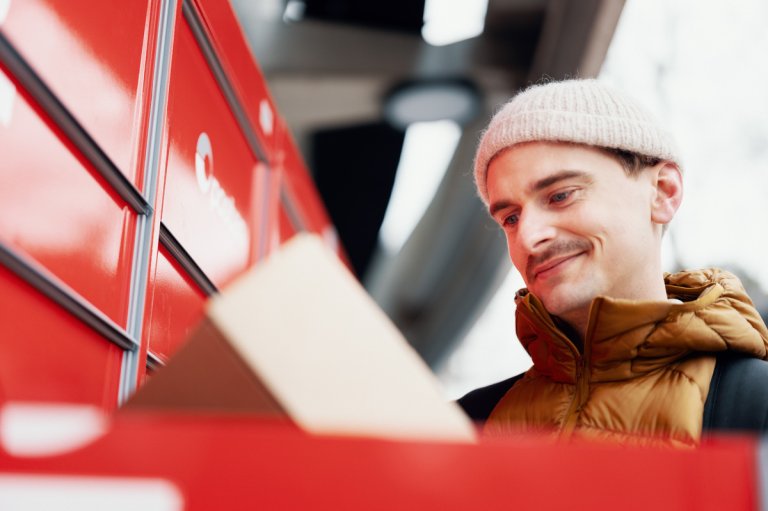 Ung mann henter pakke i pakkeboks