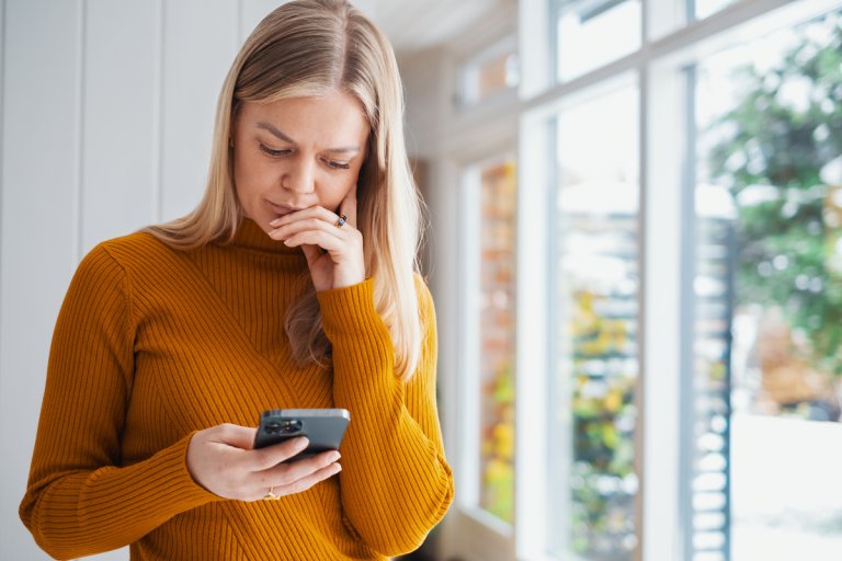 Kvinne ser på mobilen sin