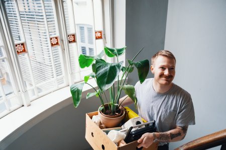 Ung mann med flyttekasse i trappeoppgang