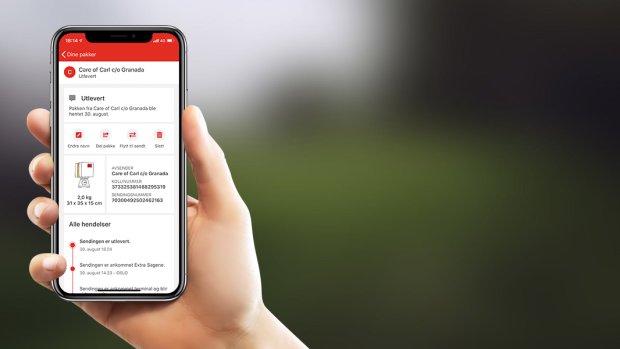 Person holder mobiltelefon med Posten-appen