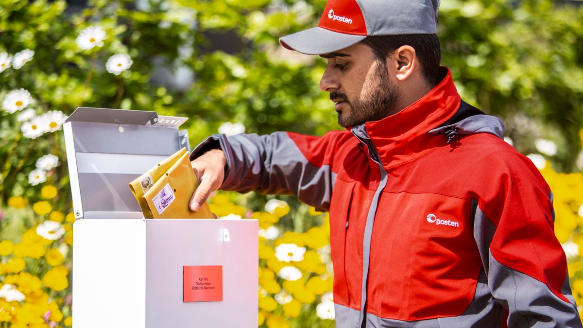 Postbud henter brev i postkasse