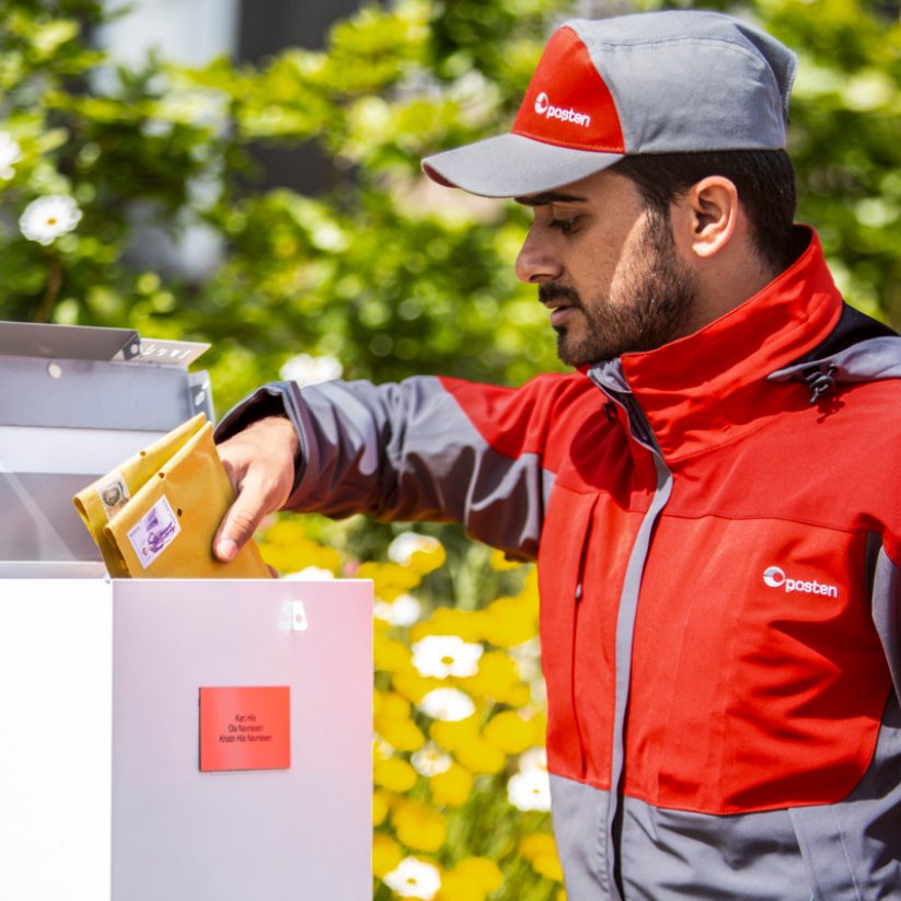 Postbud henter brev i postkasse