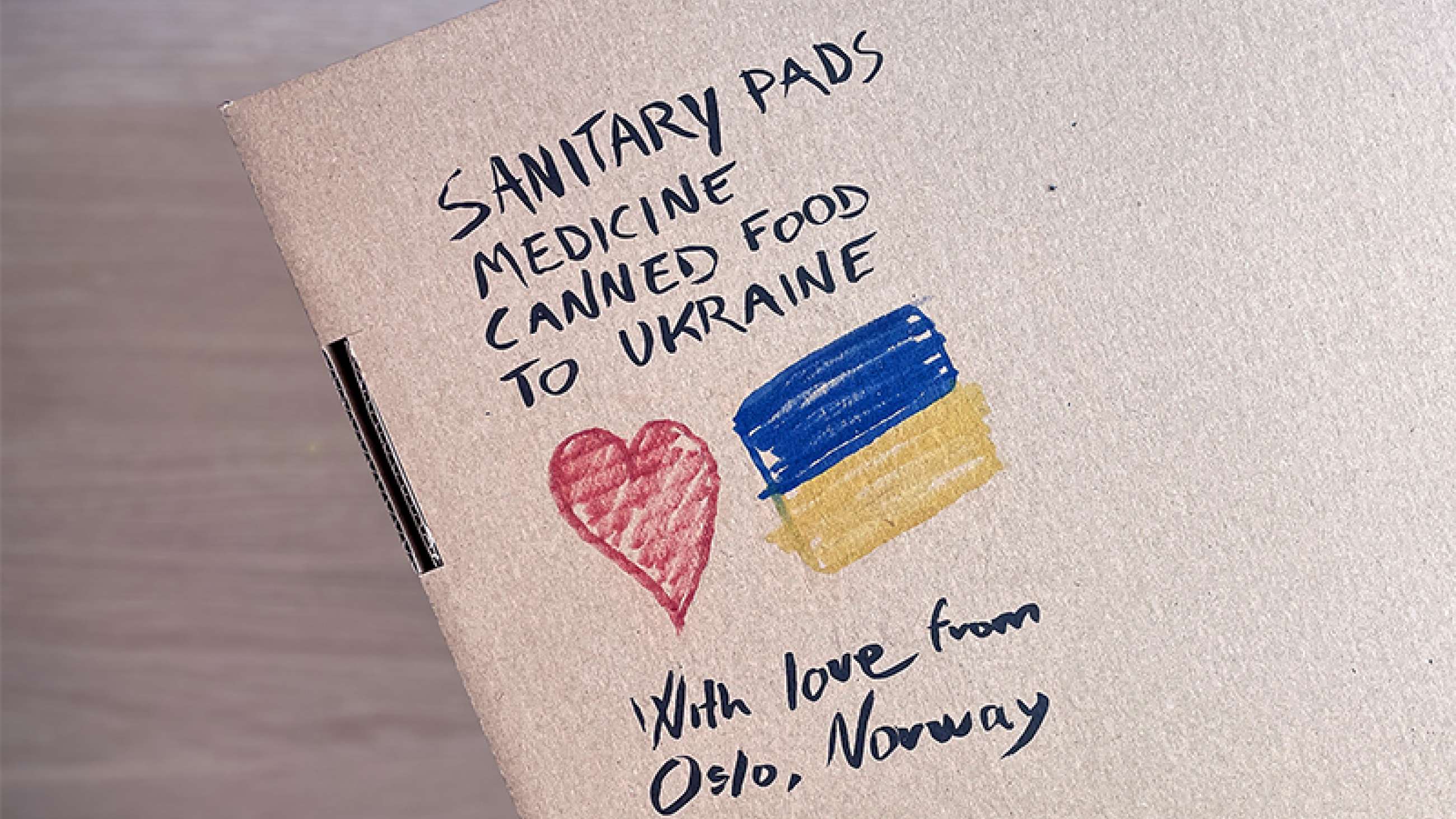 Pakke med nødhjelp til Ukraina; med hjerte og det ukrainske flagget